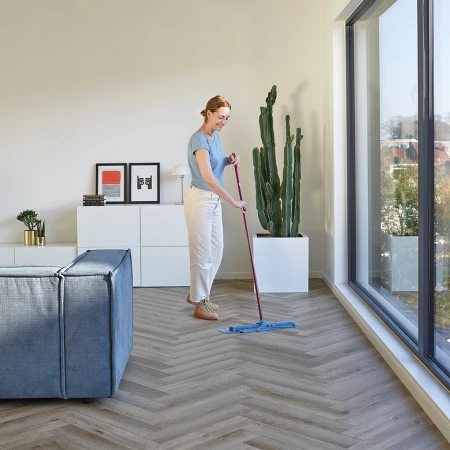 Woman cleaning her herringbone vinyl with a damp mop