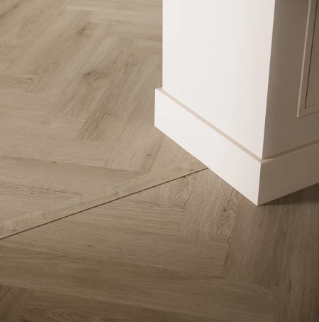 Herringbone vinyl finished with a transition profile and paintable skirting board